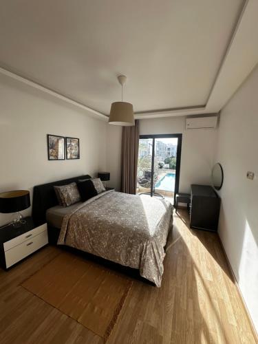 sypialnia z łóżkiem i dużym oknem w obiekcie Ocean Palm Aρραrt Pοοl Vieω w mieście Casablanca