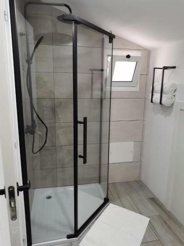 a shower with a glass door in a bathroom at Sunrise Bay - Modern Flat with stunning views in Seixal