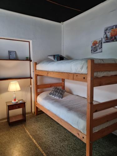 a room with three bunk beds and a lamp at Alojamiento Emilia House in Punta Arenas