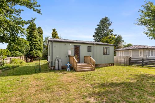 a green tiny house in a yard at Lakeside Treasure - Mangakino Holiday Home in Mangakino