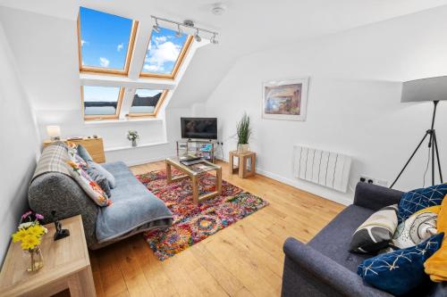 a living room with two couches and a table at Stunning 2BR Loft Apt in Oban - Sea Views in Oban