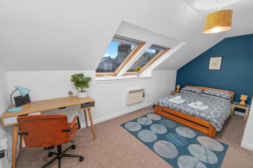 a bedroom with a bed and a desk and a desk at Argyll Apartments - High Street, Oban in Oban
