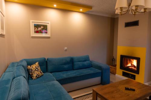a living room with a blue couch and a fireplace at GOLD apartamenty & spa in Szczawnica