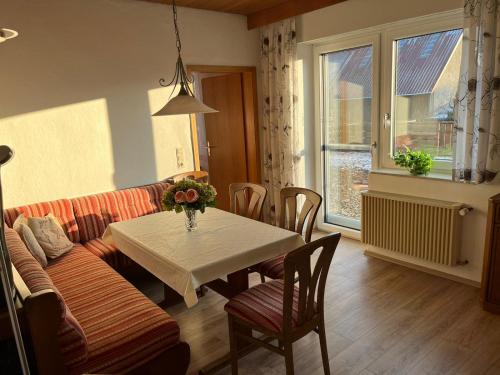 a living room with a table and a couch at Zimmer-Ferienwohnung Aalen/Westhausen in Westhausen