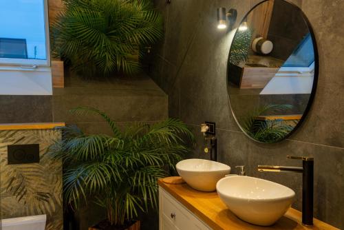 a bathroom with two sinks and a mirror at GOLD apartamenty & spa in Szczawnica
