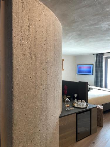 a room with a bed and a stone wall at La Rêverie de Thumel - Suite in Rhêmes-Notre-Dame