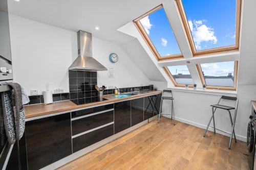 a kitchen with skylights and a counter with a stove at Stunning 2BR Loft Apt in Oban - Sea Views in Oban