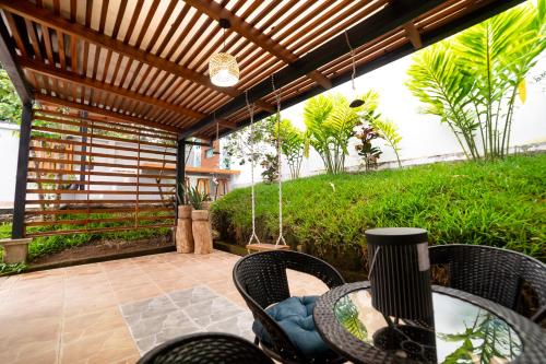 a patio with a table and chairs under a pergola at Markinkia - Estancia Amazónica in Macas