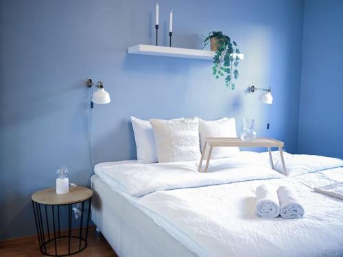 Live in a stylish home in the center of Oslo في أوسلو: غرفة زرقاء مع سرير وطاولة عليها