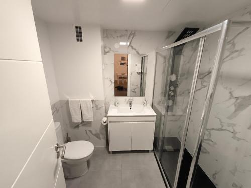 Un baño con inodoro, lavabo y ducha. en Litoral Mar, en Portimão