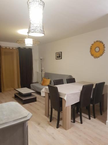 un salon avec une table, des chaises et un canapé dans l'établissement Charmant appartement à 2 pas de la plage !, à Marseille