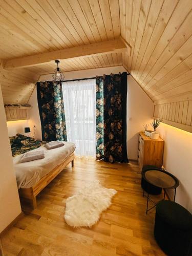 - une chambre avec un lit et une grande fenêtre dans l'établissement FAMILY HAUSE, à Witów