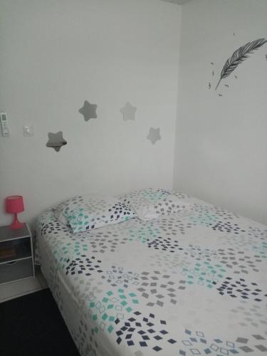 庫魯的住宿－Un T2 climatisé, une nuit，卧室配有一张灰星床,墙上挂着灰色的星星
