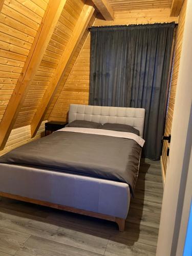 a bed in a room with a wooden ceiling at Cabana Stil A in Mărişel
