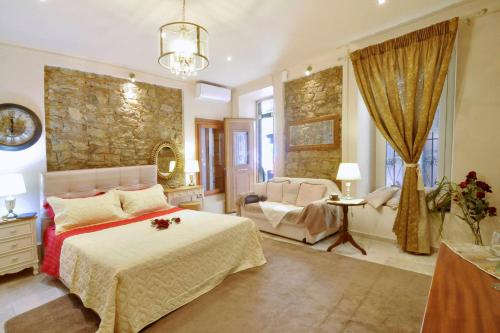 a bedroom with a bed and a chair in a room at Venetian Suite Mitropolis new in Corfu