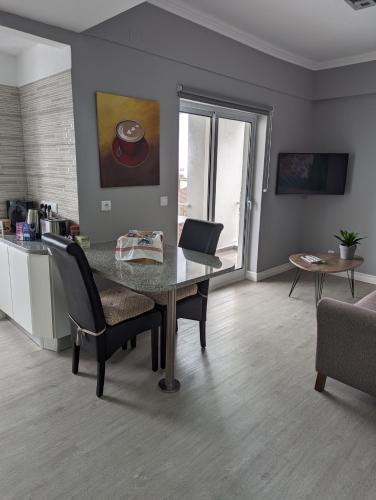 a living room with a table and chairs and a kitchen at Waterfront 1 Bedroom suite 3 adults PDL in Ponta Delgada