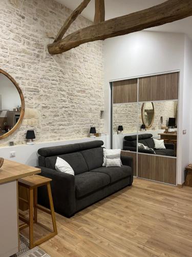 un salon avec un canapé et un miroir dans l'établissement Chez Bibou, à Anais