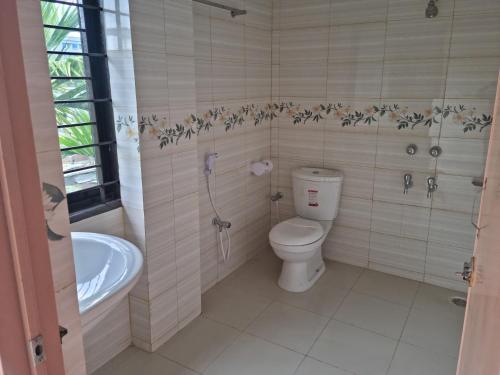 a bathroom with a toilet and a shower and a sink at Moshahid Ali House in Sylhet