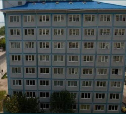 a tall gray building with a blue roof at Ceronav Portului Studio in Galaţi