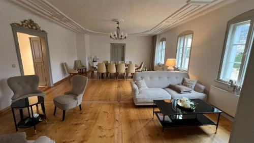 a living room with a white couch and a table at Feine Wohn und Schlafstuben im Herrenhof I UNESCO Welterbe I Parkplatz I Erzgebirge I Waldbühne in Schwarzenberg