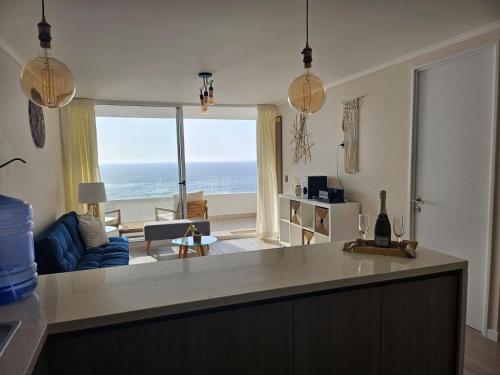 a kitchen and living room with a view of the ocean at Departamento con espectacular vista al mar Arica, Condominio Ayllu in Arica