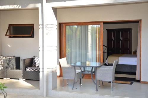 a room with a table and chairs and a bed at Hill Top Villa - Private Room In A Home in Hazyview