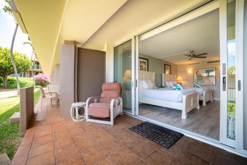 a bedroom with a bed and a chair at Eldorado E104 in Kahana