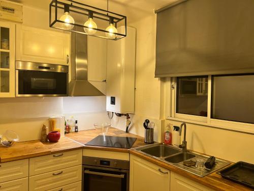 une cuisine avec un évier et une cuisinière dans l'établissement Studio Climatisé Refait à neuf #16, à Toulon