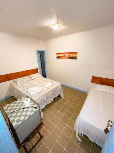 a room with two beds and a table at Recanto das Estrelas in Marau