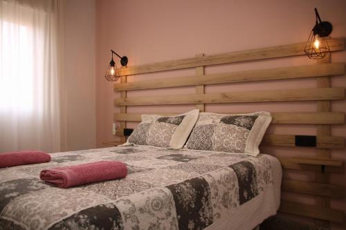 a bedroom with a wooden headboard and a bed with pillows at El Rincón de Eli in Rincón de la Victoria