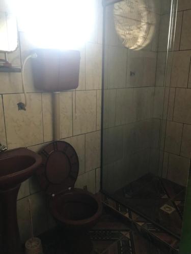 a dirty bathroom with a toilet and a sink at Michele in São Pedro da Aldeia