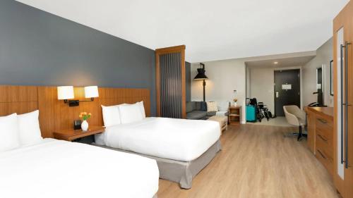 a hotel room with two beds and a living room at Hyatt Place San Juan in San Juan