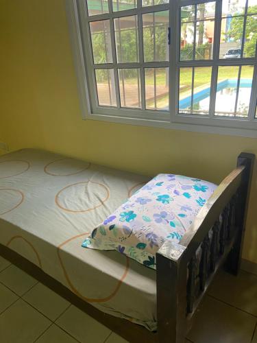 - un petit lit dans une chambre avec fenêtre dans l'établissement La Casa Del Lago, à Posadas
