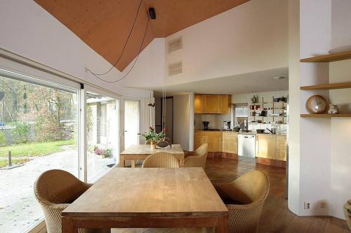 een keuken met een houten tafel en stoelen bij Comfortabele woning aan het water, hottub & kachel in Zuidlaren