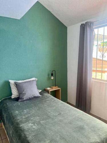 a green bedroom with a bed and a window at Depto. equipado, Dos Habitaciones, Zona Céntrica in Tulancingo