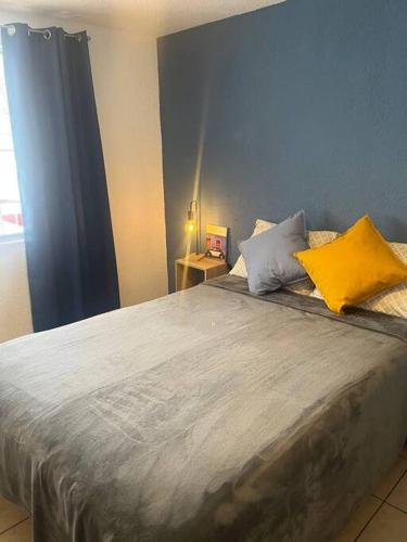 a bedroom with a large bed with yellow and gray pillows at Depto. equipado, Dos Habitaciones, Zona Céntrica in Tulancingo