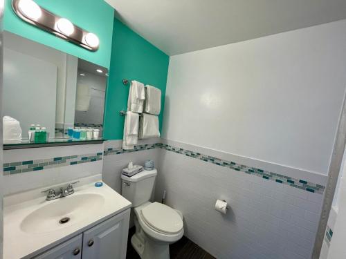 a bathroom with a white toilet and a sink at Nobleton Hotel in Fort Lauderdale