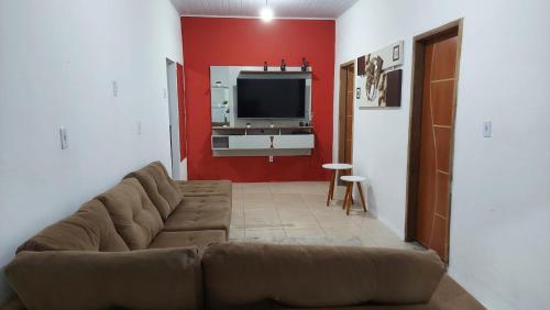 uma sala de estar com um sofá e uma televisão de ecrã plano em Casa em Pradim de açúcar em Prado