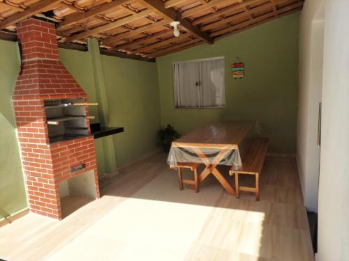 um quarto com uma lareira de tijolos e uma mesa em Casa em Pradim de açúcar em Prado