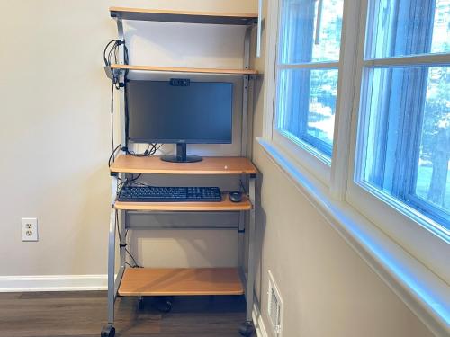 a computer on a shelf in a room with windows at Serene Landing Place near Downtown Cary in Cary