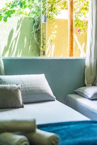 a bed sitting in a room with a window at Portuá Chalés in São Miguel dos Milagres