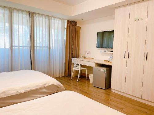 a hotel room with a desk and a bed at Hotel Huru House in Taichung