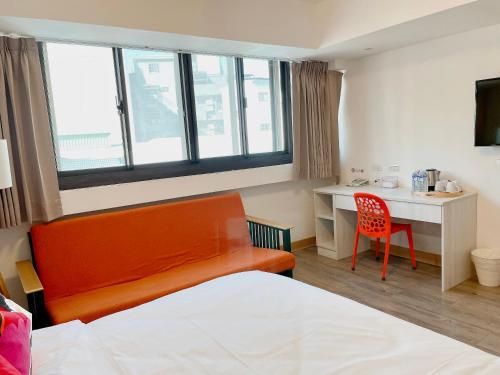 a room with a bed and a desk and a chair at Hotel Huru House in Taichung