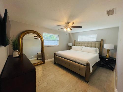 a bedroom with a bed with a ceiling fan and a mirror at Sarasota Paradise home near Siesta Key Beach in Sarasota