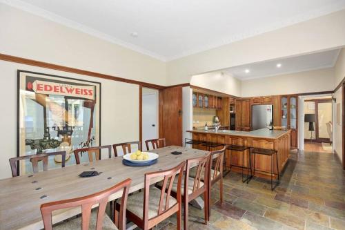 a kitchen and dining room with a wooden table and chairs at Grand View with Spa & Sauna in Warburton