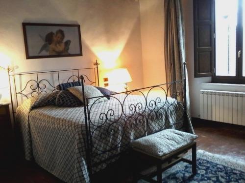 a bedroom with a bed and a chair and a window at Cisterna Nel Borgo in Castiglione dʼOrcia