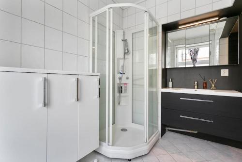 a white bathroom with a shower and a sink at Aalesund centrum apartement. in Ålesund