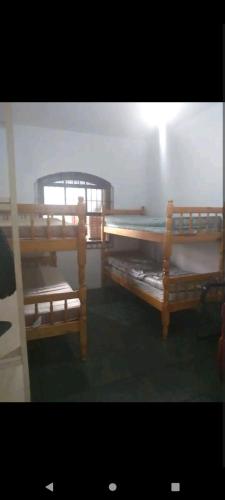- 2 lits superposés en bois dans une chambre dans l'établissement Casa com piscina, à Caraguatatuba