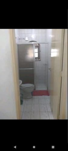 a small bathroom with a toilet and a shower at Casa com piscina in Caraguatatuba