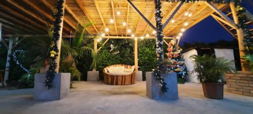 um pavilhão exterior com uma banheira e luzes de Natal em Hostal El Cascol em Puerto López